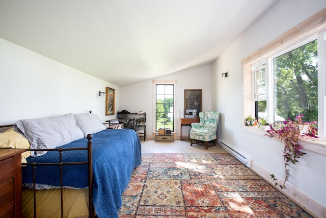 bedroom with lofted ceiling, a baseboard heating unit, and carpet