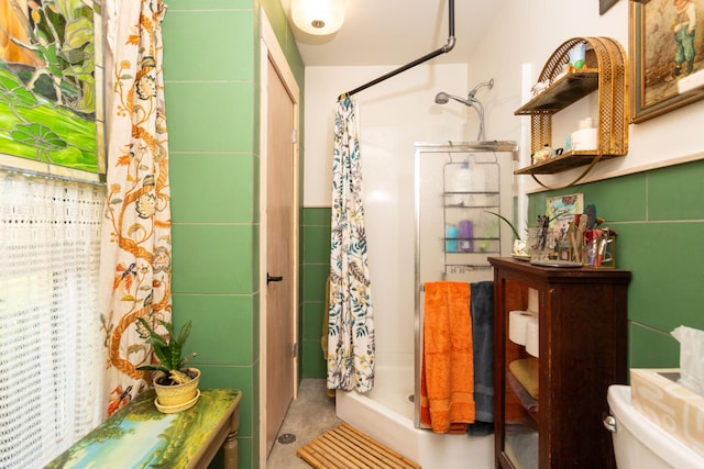 bathroom featuring toilet, walk in shower, and tile walls