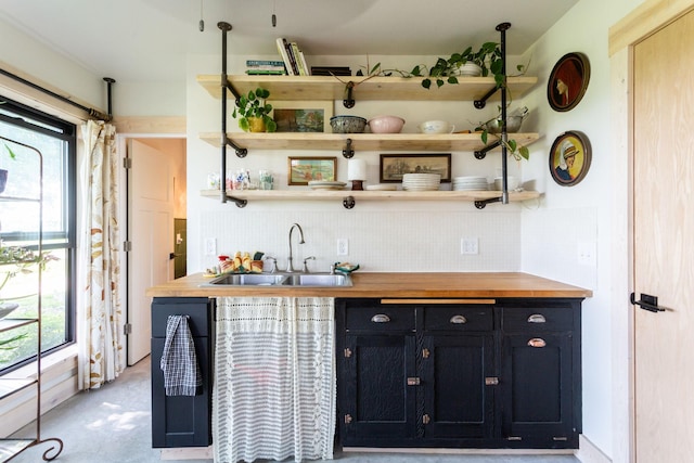 bar with wooden counters, sink, and plenty of natural light