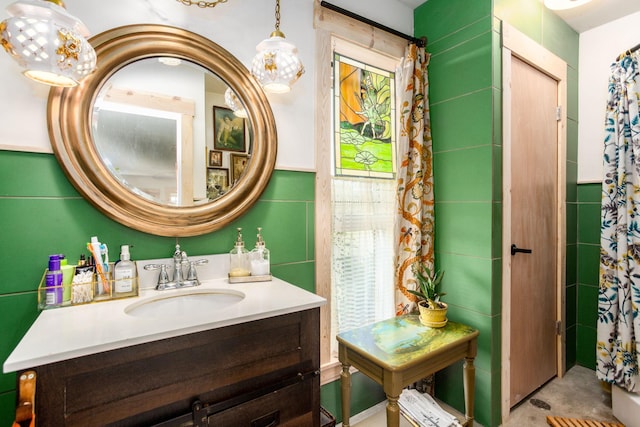 bathroom with vanity, a shower with curtain, and tile walls