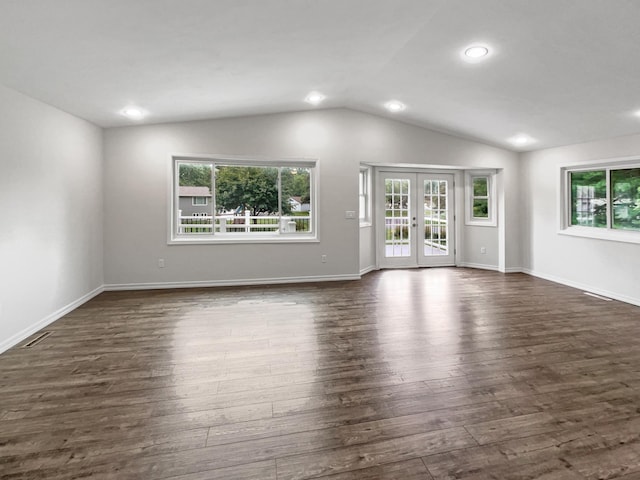 unfurnished living room featuring vaulted ceiling, plenty of natural light, and dark wood-type flooring