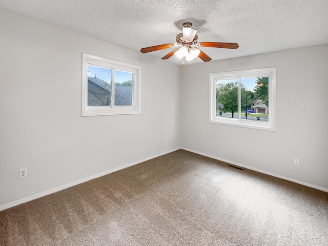 unfurnished room featuring a textured ceiling, carpet, and ceiling fan