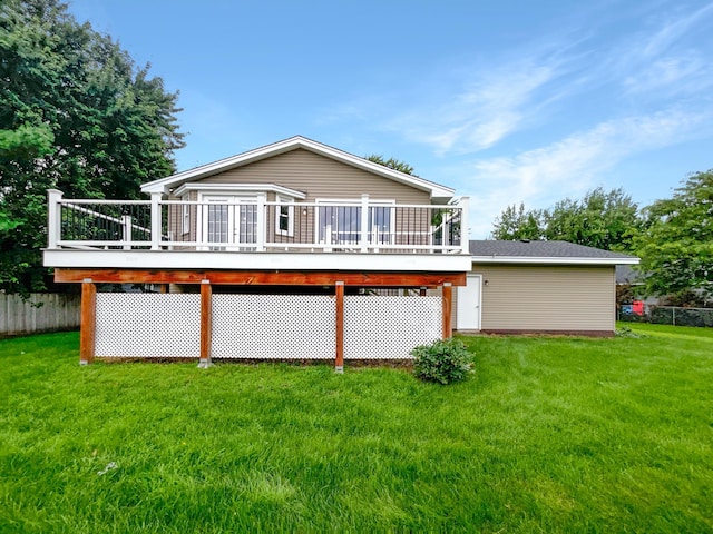 rear view of house with a deck and a yard