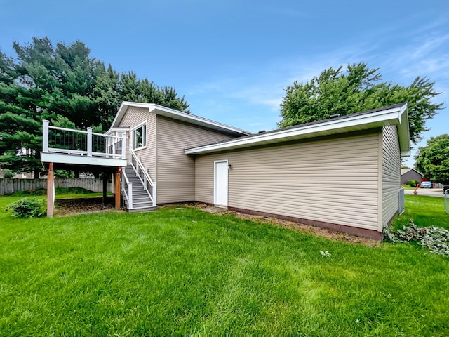 back of house with a lawn and a deck