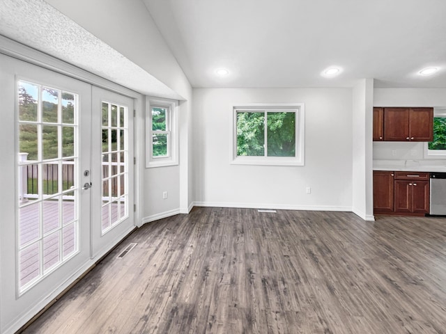 unfurnished living room featuring vaulted ceiling, french doors, and hardwood / wood-style flooring