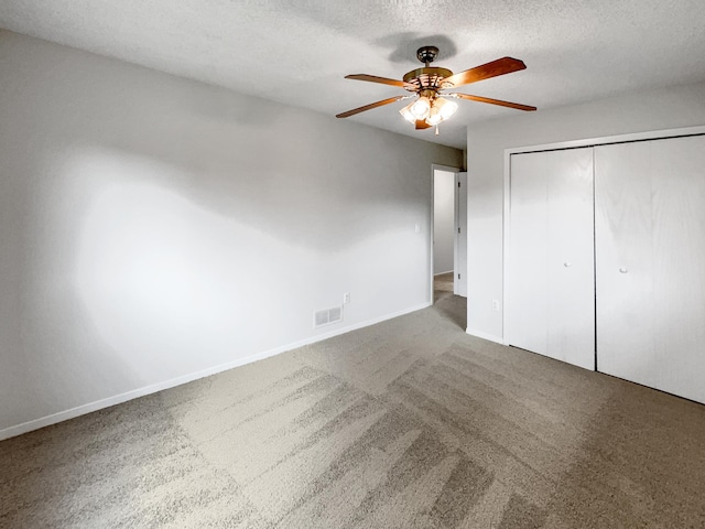 unfurnished bedroom featuring a closet, ceiling fan, carpet floors, and a textured ceiling