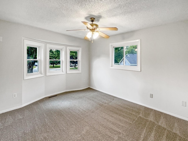 carpeted spare room with ceiling fan and a textured ceiling