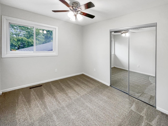 unfurnished bedroom featuring carpet, ceiling fan, and a closet