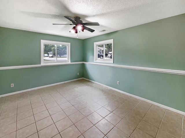 tiled spare room with ceiling fan and a textured ceiling