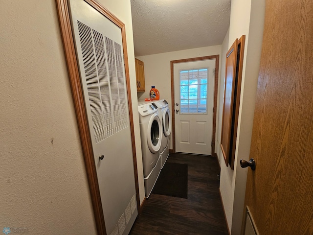 washroom with dark hardwood / wood-style floors, washing machine and dryer, cabinets, and a textured ceiling