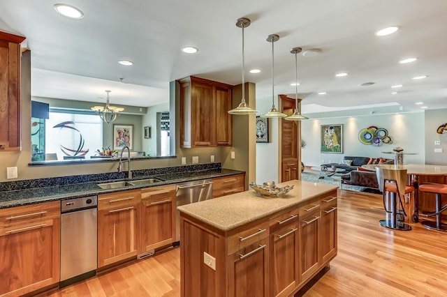 kitchen featuring sink, light hardwood / wood-style floors, decorative light fixtures, a center island, and dishwasher