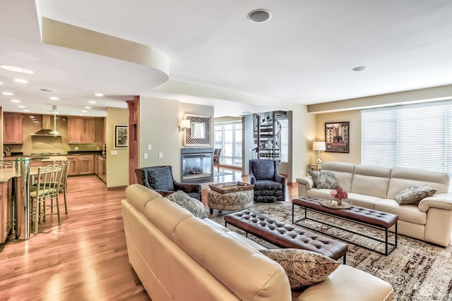 living room featuring light hardwood / wood-style floors and a multi sided fireplace