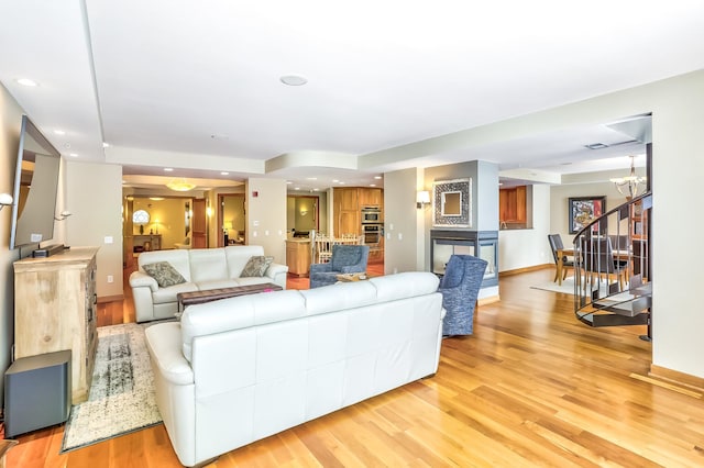 living room with a notable chandelier and light wood-type flooring