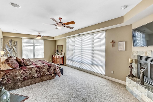 bedroom with carpet, multiple windows, a fireplace, and ceiling fan