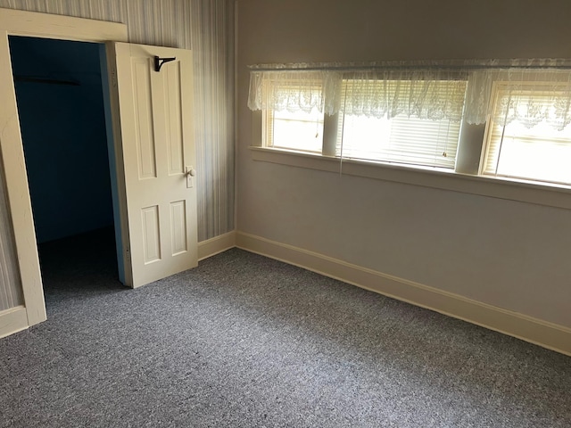 unfurnished bedroom with carpet, a walk in closet, and a closet