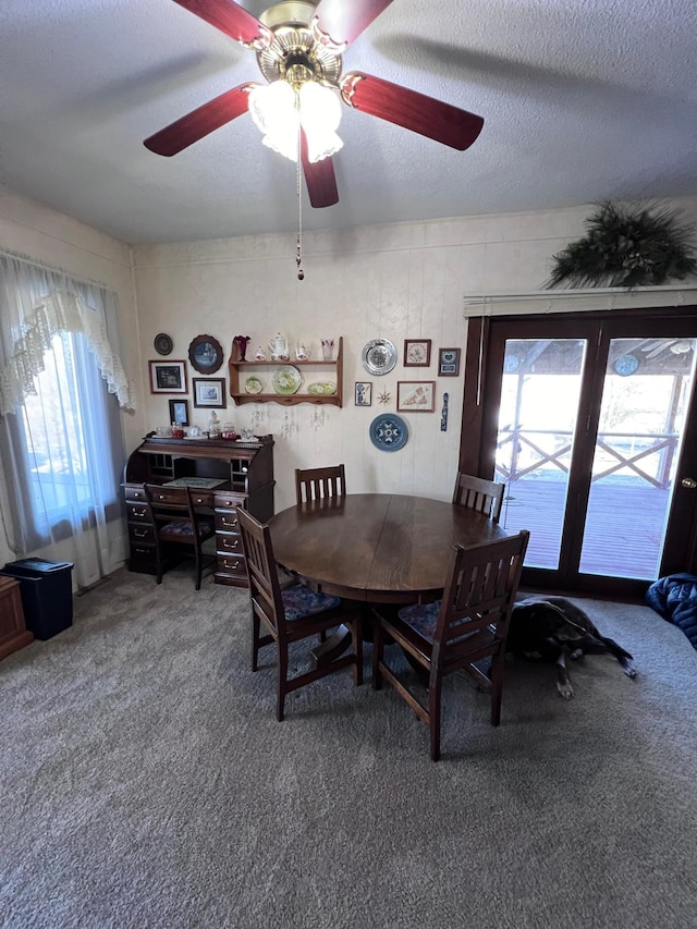 carpeted dining area featuring a textured ceiling and ceiling fan