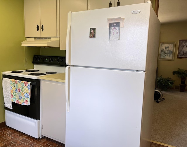 kitchen featuring freestanding refrigerator, range with electric cooktop, brick floor, under cabinet range hood, and light countertops