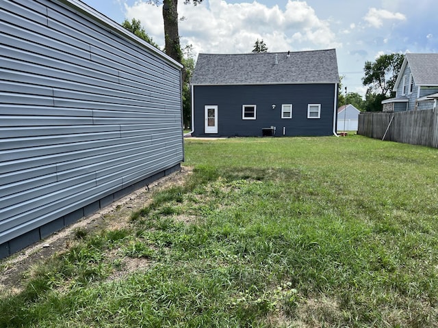 view of yard featuring fence and central AC