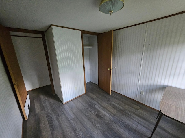 unfurnished bedroom featuring dark wood-type flooring and a closet