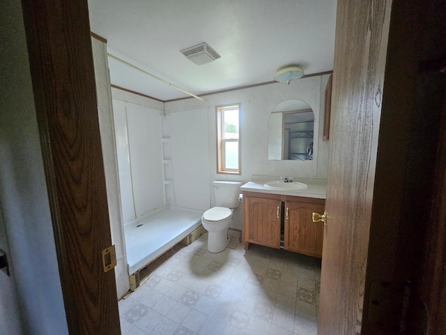 bathroom with walk in shower, vanity, and toilet