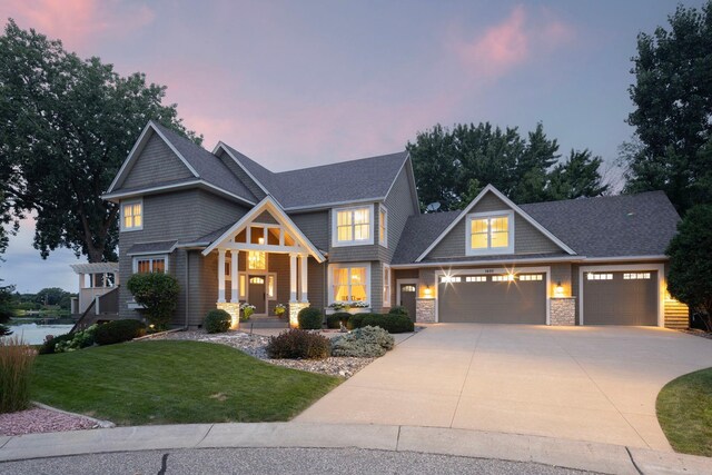 craftsman-style house with a garage and a lawn