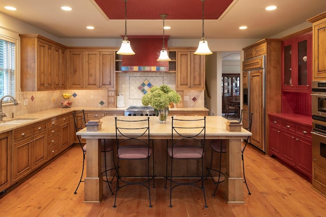 kitchen featuring open shelves, custom range hood, a sink, paneled built in refrigerator, and light wood-type flooring