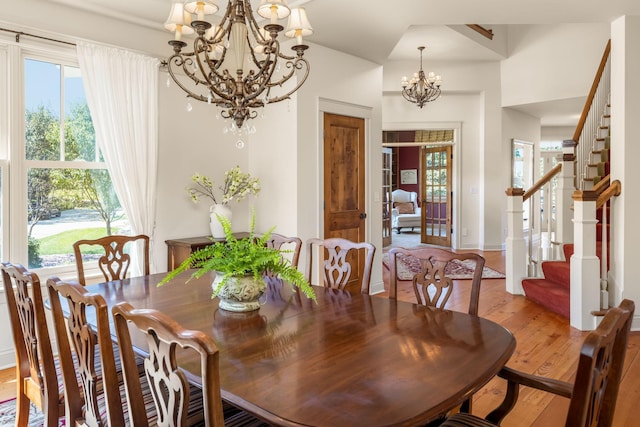 dining room featuring baseboards, stairs, a chandelier, and hardwood / wood-style floors