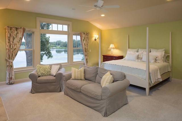 bedroom featuring lofted ceiling, a water view, carpet flooring, and multiple windows