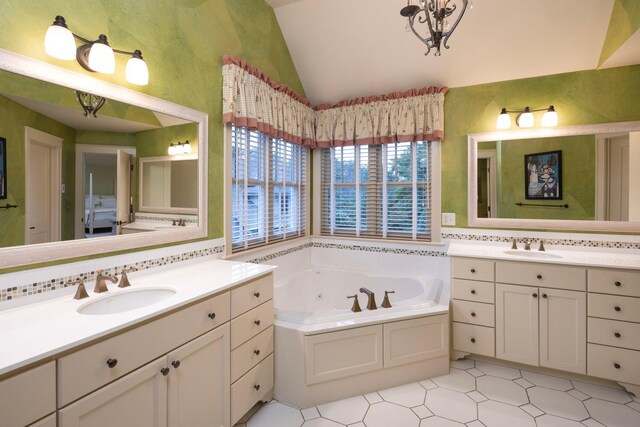 bathroom featuring backsplash, tile patterned floors, vaulted ceiling, a tub to relax in, and double sink vanity