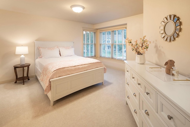 bedroom featuring light colored carpet and baseboards