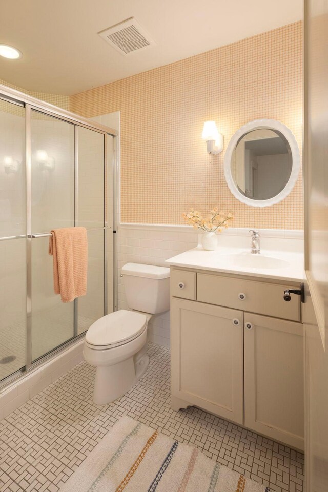 bathroom featuring an enclosed shower, vanity, toilet, and tile patterned floors