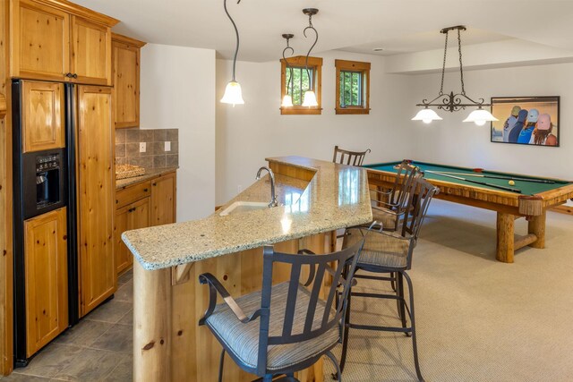 kitchen with paneled fridge, billiards, backsplash, hanging light fixtures, and sink