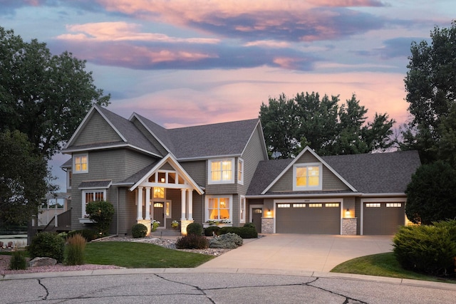 view of front facade featuring a garage, stone siding, driveway, and a front lawn