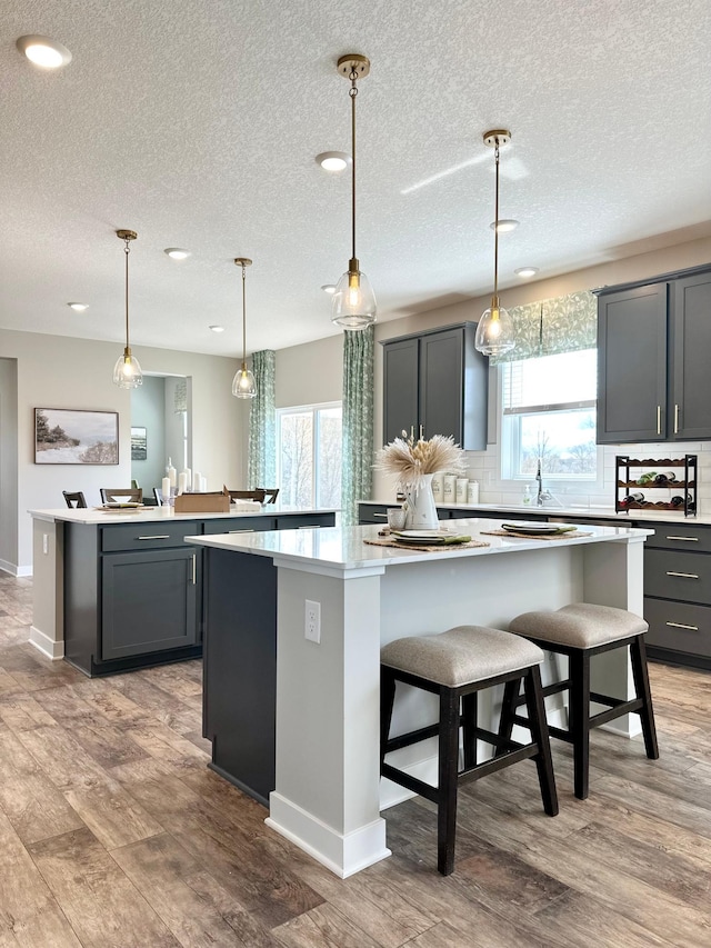 kitchen featuring gray cabinetry, a large island, and light wood-type flooring