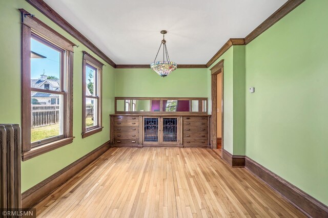 interior space featuring light hardwood / wood-style floors, radiator, and ornamental molding