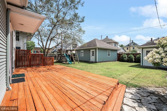 wooden terrace with an outbuilding, a lawn, and a playground