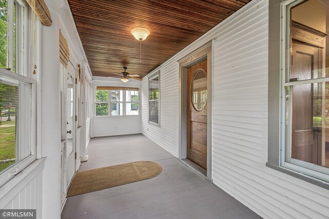 unfurnished sunroom with wood ceiling and ceiling fan