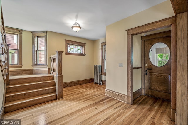 foyer with radiator, light wood-type flooring, and a wealth of natural light