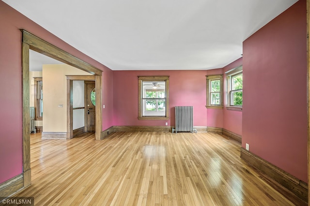 empty room with radiator and light hardwood / wood-style flooring