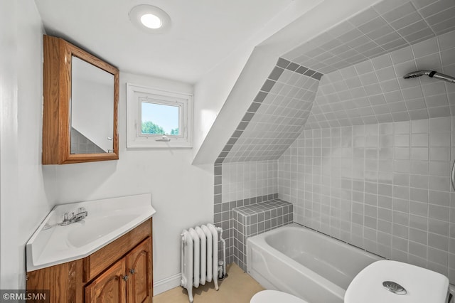 full bathroom with vanity, radiator heating unit, tiled shower / bath, toilet, and lofted ceiling