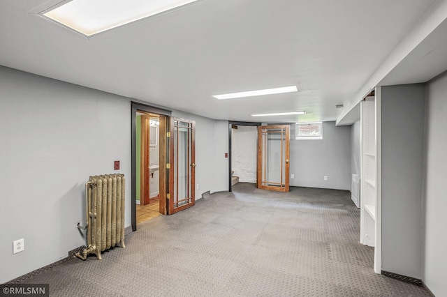 basement with light carpet and radiator heating unit