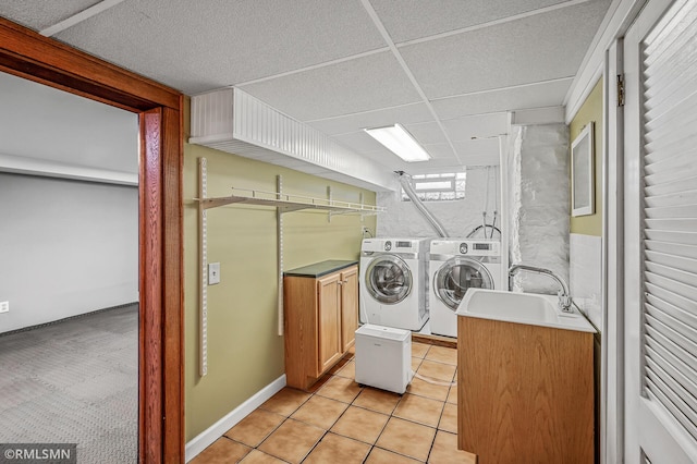 laundry area with cabinets, separate washer and dryer, sink, and light tile patterned floors