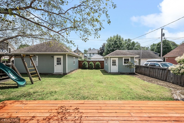 view of yard featuring a deck, an outdoor structure, and a playground