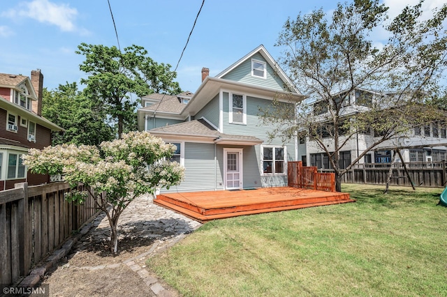 rear view of property featuring a yard and a wooden deck