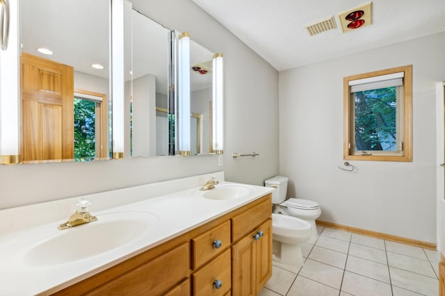 bathroom featuring toilet, a textured ceiling, a bidet, vanity, and tile patterned flooring