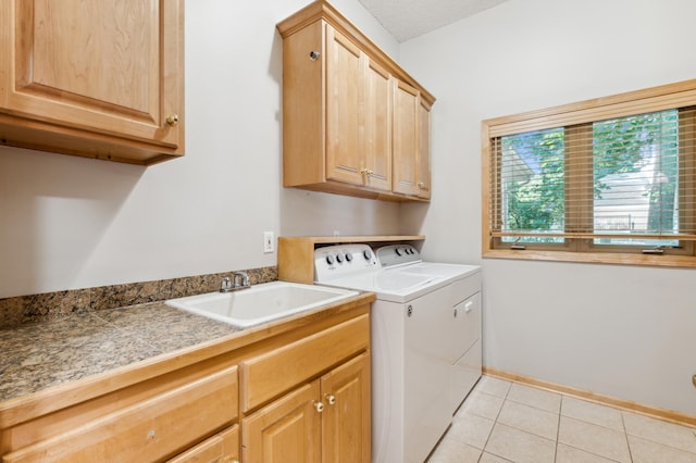 laundry room with cabinets, sink, washing machine and dryer, and light tile patterned floors