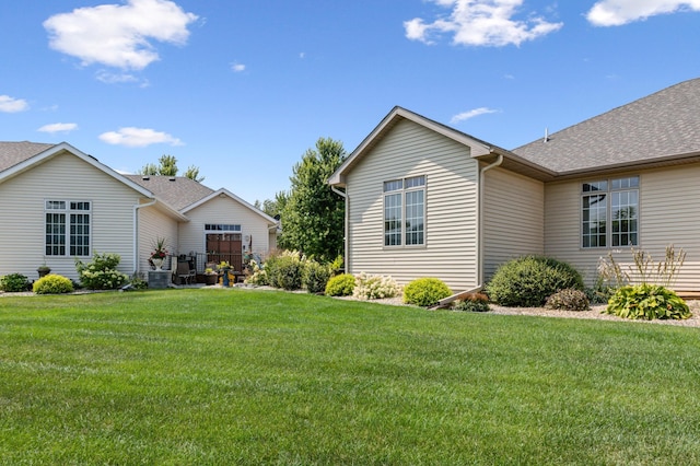 view of home's exterior with cooling unit and a lawn