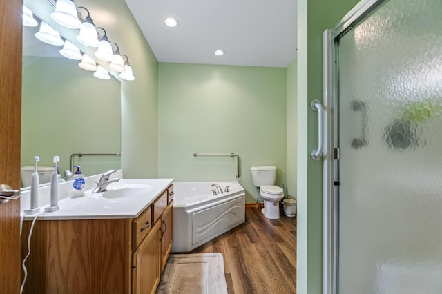 full bathroom featuring wood-type flooring, separate shower and tub, vanity, and toilet