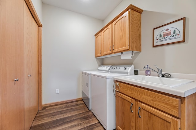 washroom with separate washer and dryer, sink, dark hardwood / wood-style floors, and cabinets