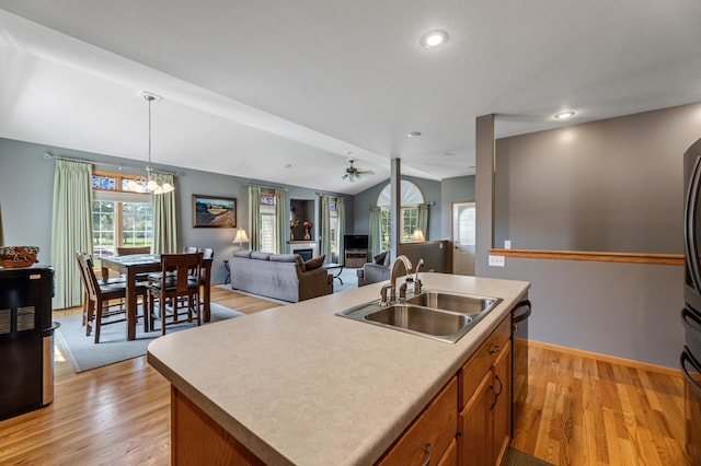 kitchen featuring sink, a healthy amount of sunlight, and an island with sink